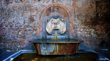 Aventine: Fountain with large mask outside of the Orange garden